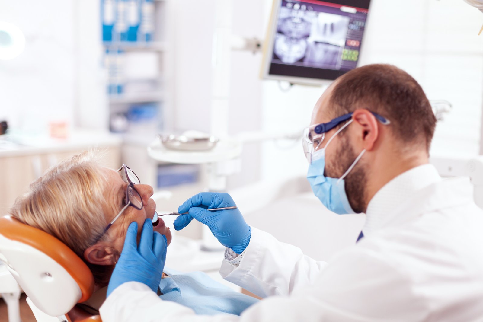 Dentist consulting with a senior patient during a dental checkup